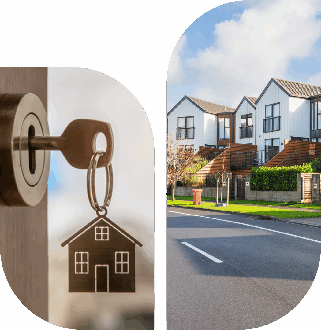 A key with a house-shaped keychain next to a suburban neighborhood street.